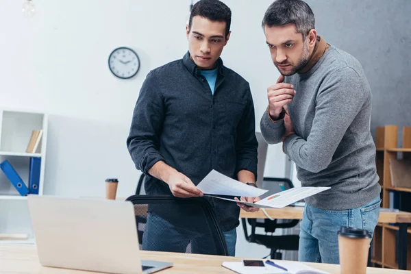 Seri uomini d'affari professionisti che lavorano con i documenti e guardando il computer portatile in ufficio — Foto stock