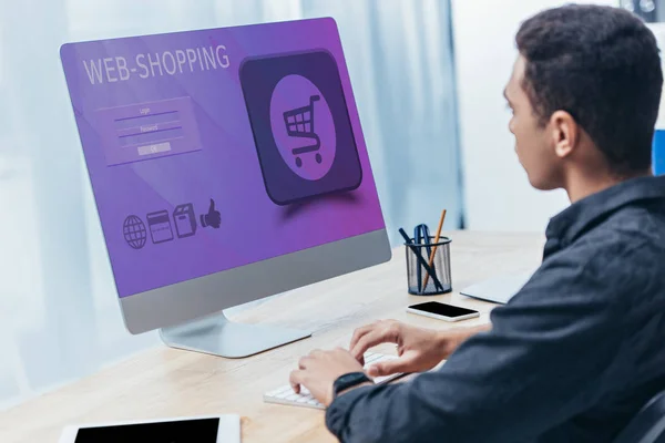 Молодий бізнесмен використовує настільний комп'ютер з веб-сайтом для покупок на екрані в офісі — стокове фото