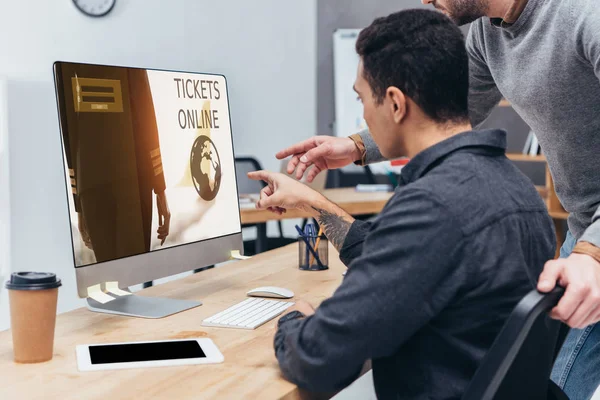 Abgeschnittene Aufnahme von Geschäftskollegen mit Desktop-Computer mit Tickets Online-Website auf dem Bildschirm im Büro — Stockfoto