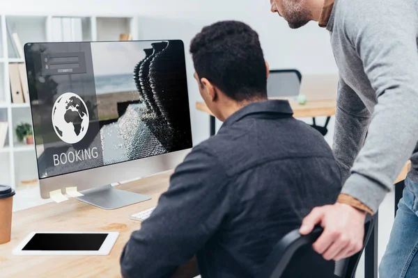 Cropped shot of business colleagues using desktop computer with booking website on screen in office — Stock Photo