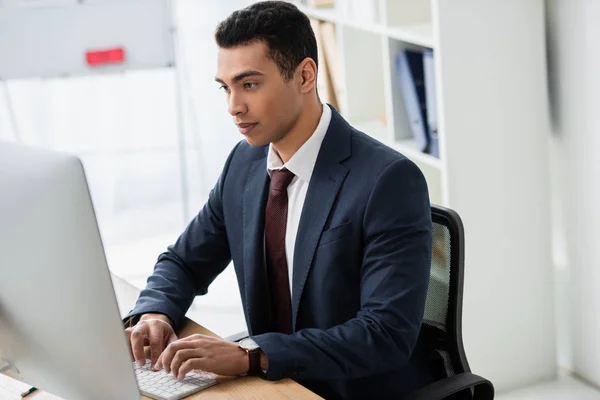 Focalizzato giovane uomo d'affari che lavora con computer desktop in ufficio — Foto stock