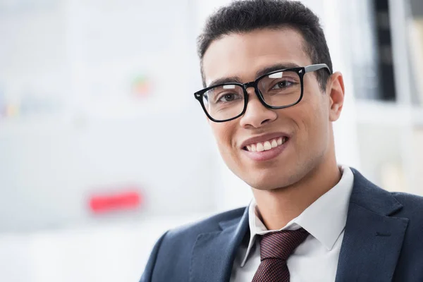 Portrait of handsome young businessman in eyeglasses smiling at camera — Stock Photo