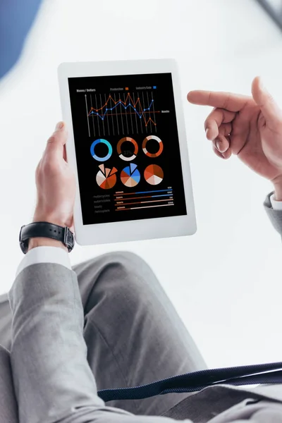 Partial view of businessman using digital tablet with business charts and graphs — Stock Photo