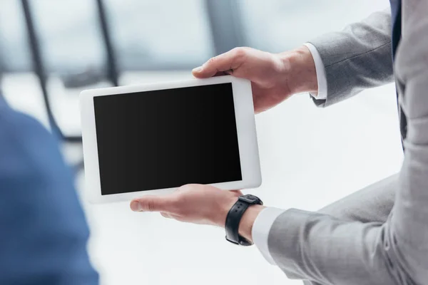 Vista parcial del empresario sosteniendo tableta digital con pantalla en blanco - foto de stock