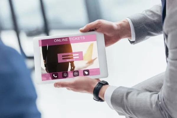 Partial view of businessman holding digital tablet with online tickets app on screen — Stock Photo