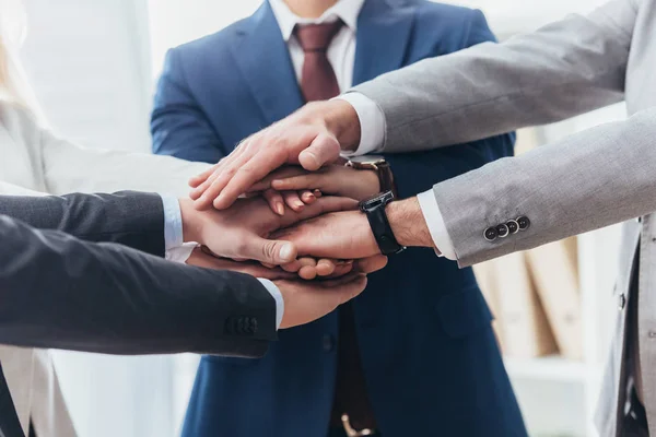 Partial view of professional business people stacking hands together — Stock Photo