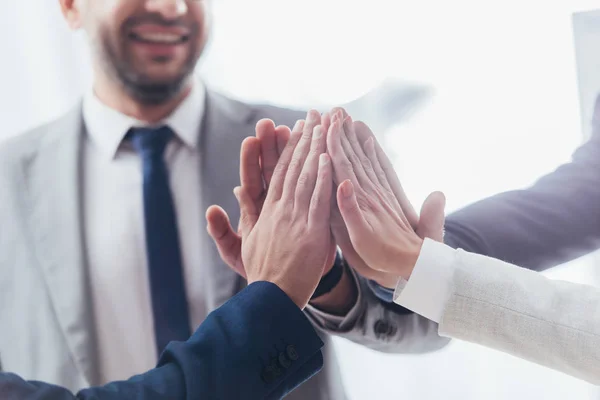 Cropped shot of professional  business team giving high five in office — Stock Photo