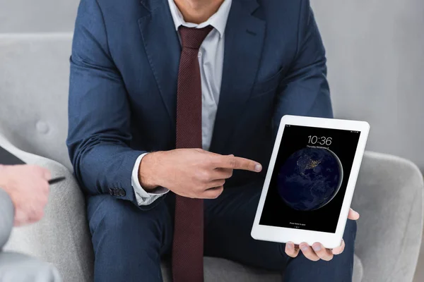 Cropped shot of businessman in formal wear pointing with finger at digital tablet — Stock Photo