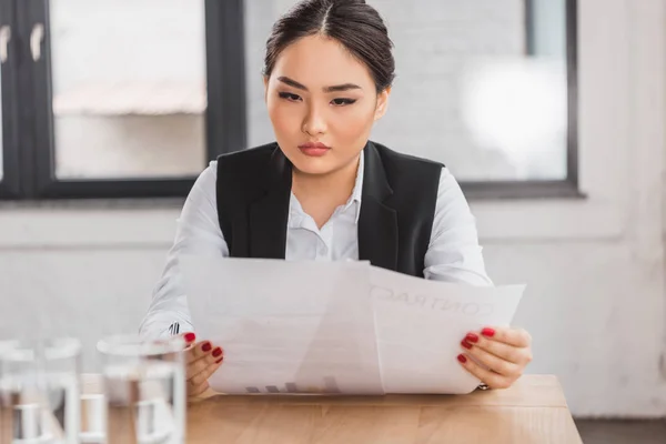 Bela mulher de negócios kazakh concentrada que trabalha com contrato no escritório — Fotografia de Stock