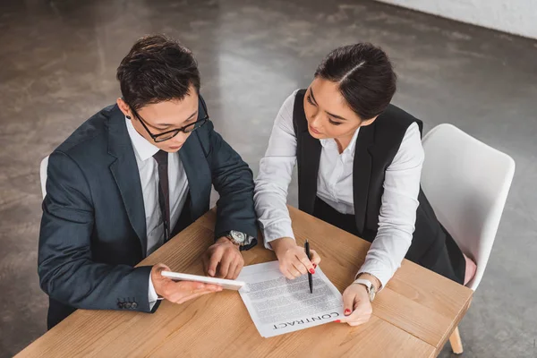 Vista ad alto angolo dei giovani colleghi di lavoro professionisti che utilizzano tablet digitale e discutono del contratto in ufficio — Foto stock