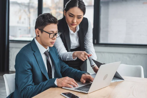 Jovens empresários kazakh usando laptop juntos no escritório — Fotografia de Stock