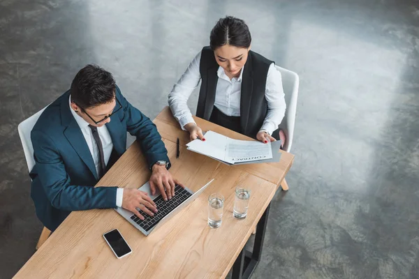 Vue grand angle de jeunes gens d'affaires asiatiques travaillant avec ordinateur portable et contrat dans le bureau — Photo de stock