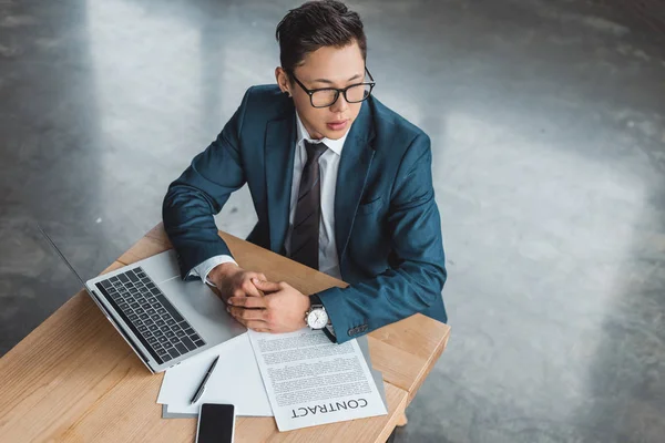 Vue grand angle de beau jeune homme d'affaires kazakh concentré assis sur le lieu de travail — Photo de stock