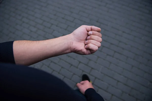 Vista recortada de la mano masculina con ladrillos en el fondo - foto de stock