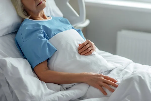 Обрізаний вид на старшу жінку, що лежить у лікарняному ліжку — стокове фото