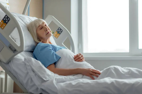 Foco seletivo da mulher idosa dormindo na cama do hospital — Fotografia de Stock