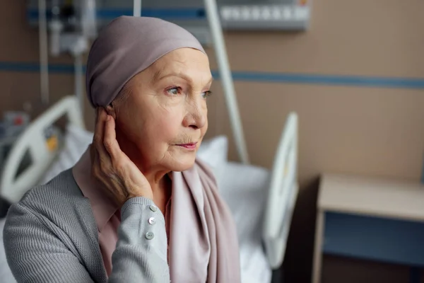 Mujer mayor con cáncer sentada en la cama en el hospital — Stock Photo