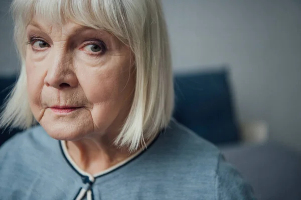 Портрет расстроенной пожилой женщины, смотрящей в камеру дома — стоковое фото
