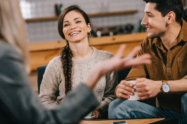 Selective focus of cheerful friends chatting in cafe — Stock Photo