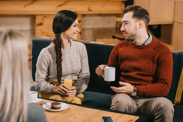 Selective focus of smiling friends chatting in cafe — Stock Photo