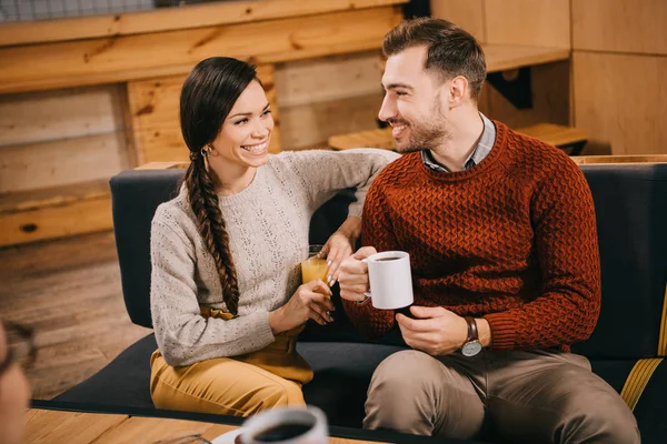 Selective focus of smiling friends looking at each other in cafe — Stock Photo