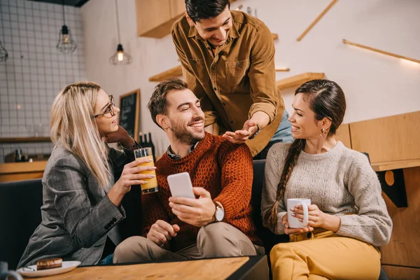 Happy group of friends smiling while holding drinks — Stock Photo