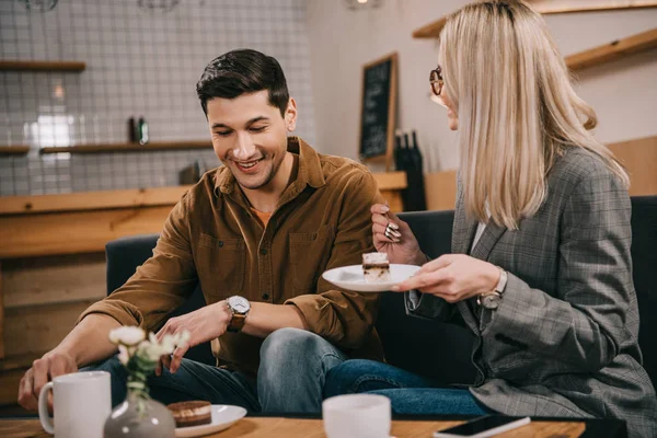 Счастливые мужчина и женщина сидят в кафе — стоковое фото