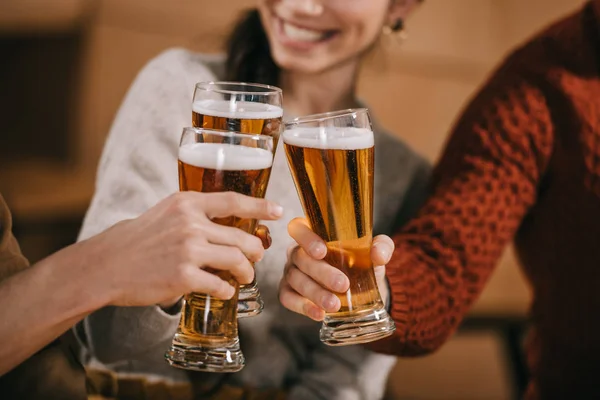 Abgeschnittene Ansicht glücklicher Freunde, die mit Bier klingeln — Stockfoto