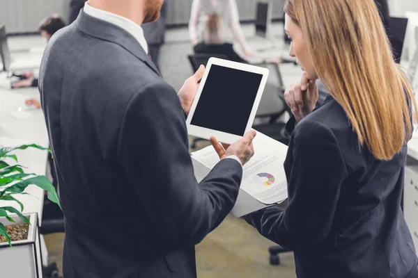 Recortado de jóvenes colegas de negocios enfocados utilizando tableta digital con pantalla en blanco en la oficina - foto de stock