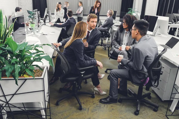 Высокий угол обзора молодых мультиэтнических бизнес-команды обсуждают работу в офисе — стоковое фото