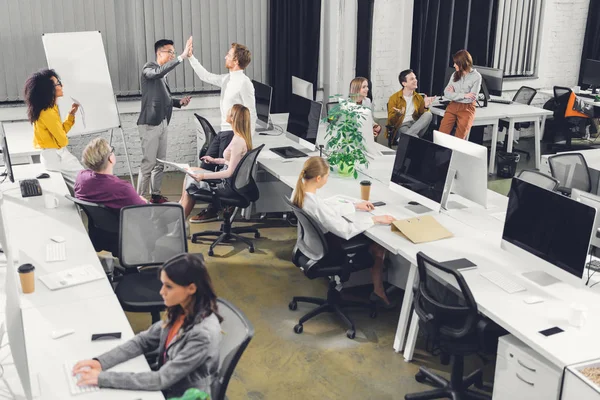 Visão de alto ângulo dos empresários multirraciais profissionais que trabalham juntos no escritório de espaço aberto — Fotografia de Stock