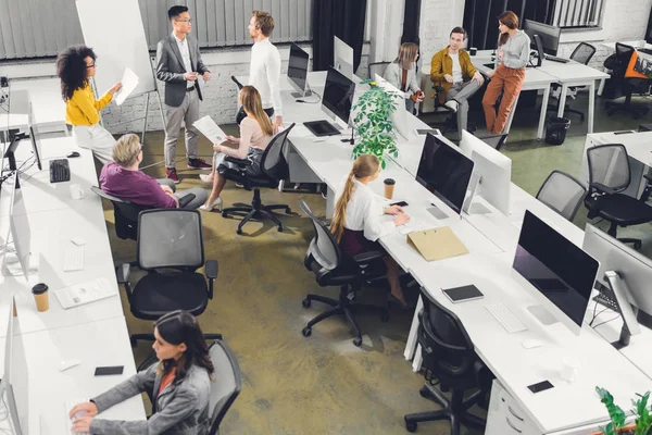 Visão de alto ângulo de jovens empresários profissionais que trabalham em conjunto no escritório de espaço aberto — Fotografia de Stock