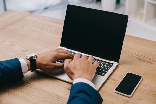 Visão cortada do empresário digitando no laptop no local de trabalho — Fotografia de Stock