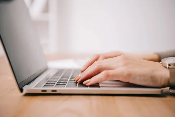 Vue recadrée de la femme d'affaires tapant sur ordinateur portable à l'espace de travail — Photo de stock