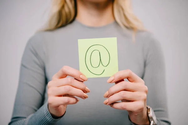 Ausgeschnittene Ansicht einer Frau mit Zettel und E-Mail-Zeichen isoliert auf grau — Stockfoto