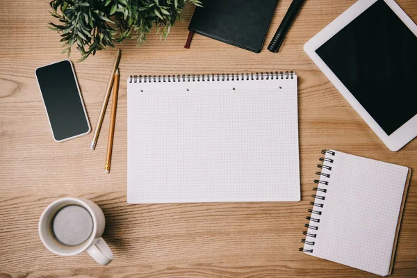 Top view of business supplies, gadgets and empty notebook on workplace — Stock Photo