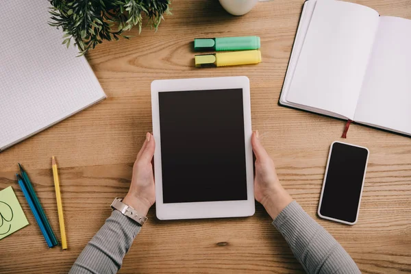 Vista dall'alto della donna d'affari che tiene tablet digitale sul posto di lavoro con smartphone e notebook — Foto stock