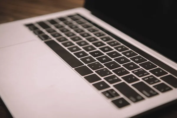 Close-up do teclado do laptop no local de trabalho de madeira — Fotografia de Stock