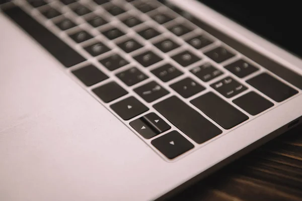 Close up of laptop keyboard on wooden table — Stock Photo