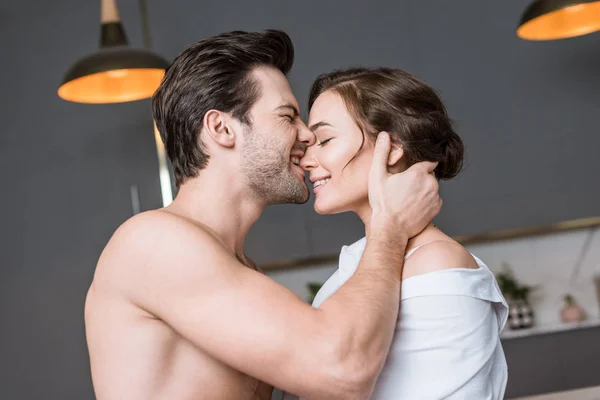 Novio adulto mordiendo novia con los ojos cerrados - foto de stock