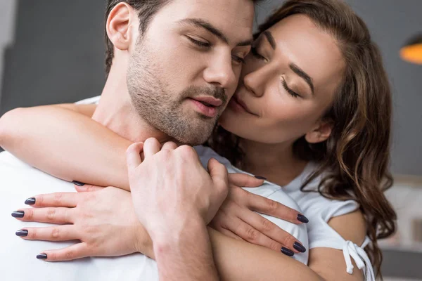 Gros plan de femme embrassant beau petit ami avec les yeux fermés — Photo de stock