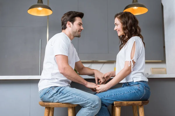 Leidenschaftlicher Mann schaut lächelnde Freundin in Küche an — Stockfoto
