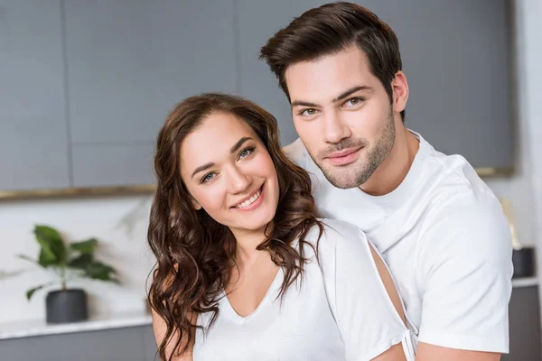 Cheerful romantic couple smiling while looking at camera — Stock Photo
