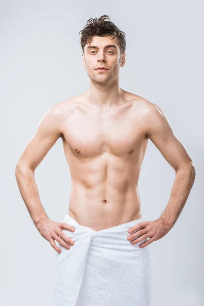 Sexy shirtless macho posing in towel isolated on grey — Stock Photo