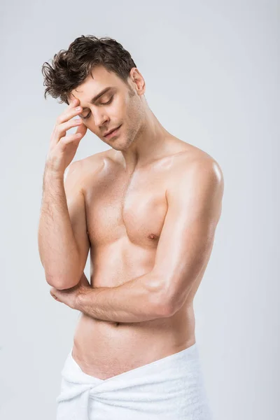 Sexy shirtless thoughtful man posing in towel isolated on grey — Stock Photo