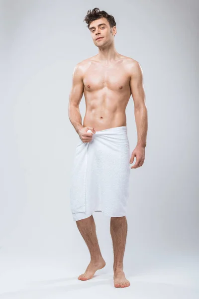Bello uomo senza camicia posa in asciugamano isolato su grigio — Foto stock