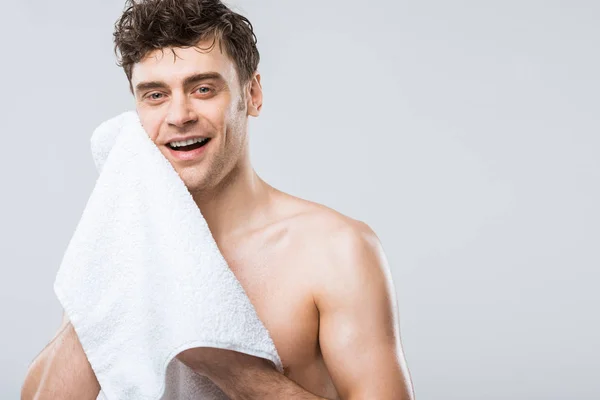 Guapo sonriente hombre limpiando con toalla aislado en gris - foto de stock