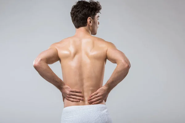 Rear view of man suffering from back pain, isolated on grey — Stock Photo