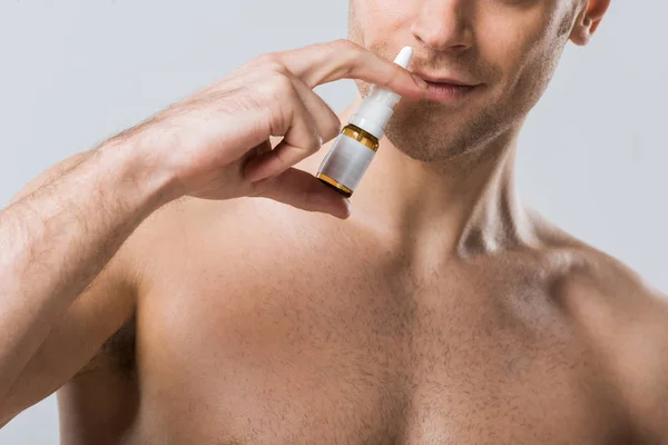 Vista ritagliata dell'uomo utilizzando spray naso, isolato su grigio — Foto stock