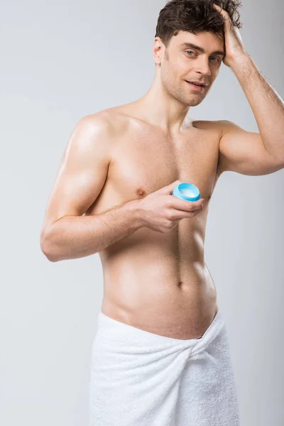 Sexy uomo senza maglietta applicare gel per capelli, isolato su grigio — Foto stock